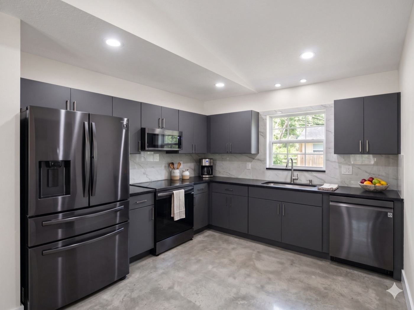 Modern grey kitchen with stainless appliances and polished concrete floor after renovation
